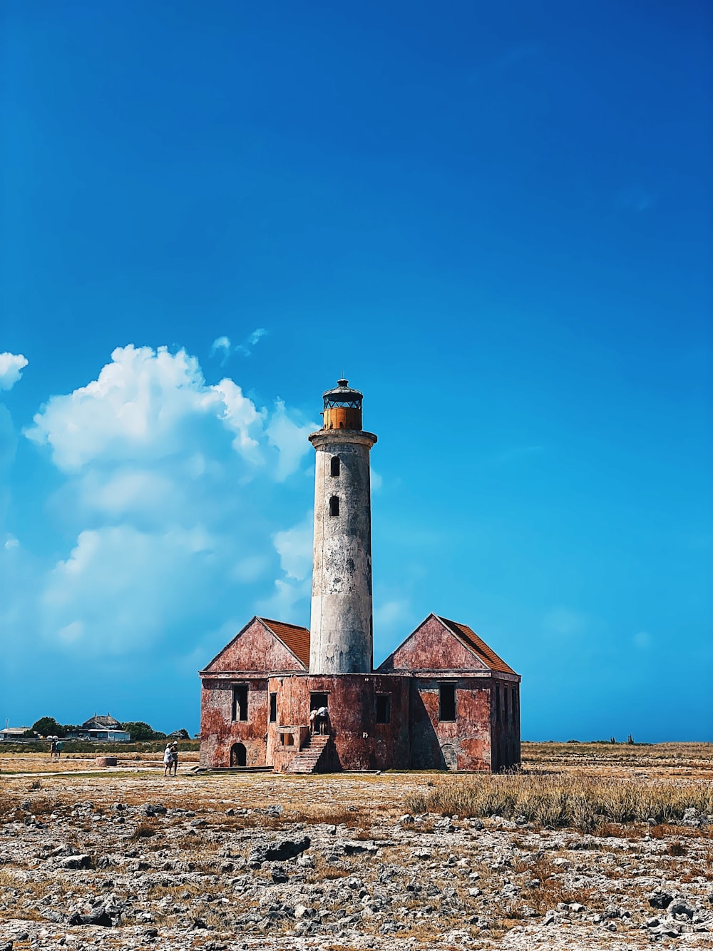 an old lighthouse sits in the middle of a field
