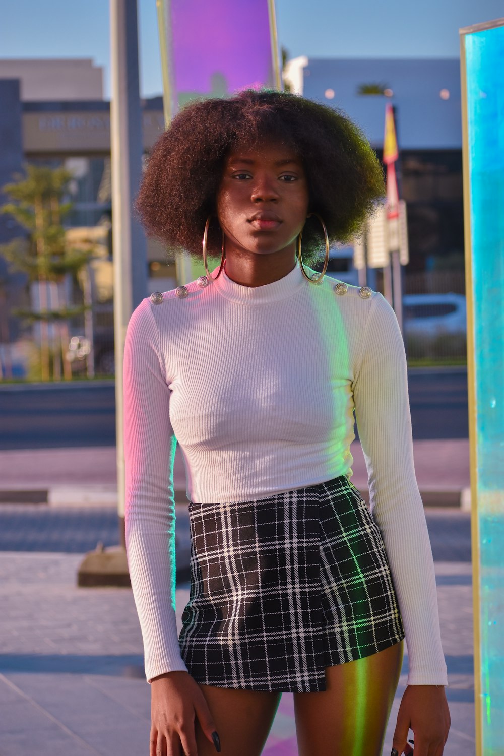a woman with an afro standing in front of a pole