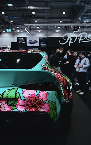 A vibrant car decal featuring a colorful floral design wrapping around the side door.