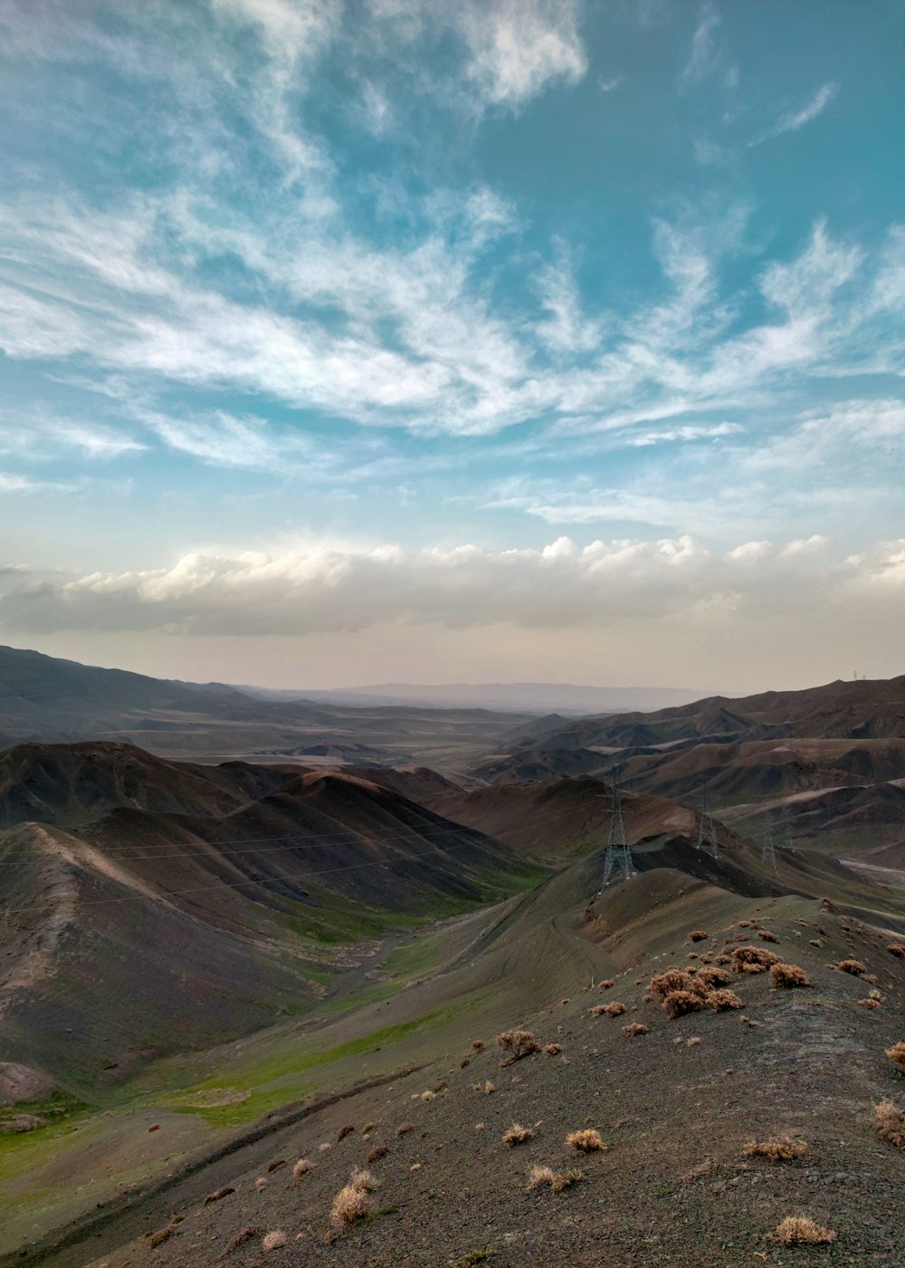 a view of a mountain range with sheep in the foreground