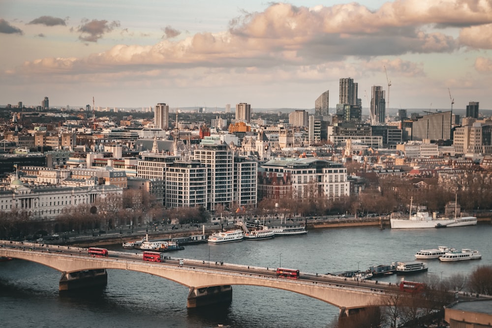 a bridge over a river with a city in the background