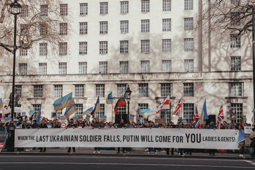 a group of people holding a banner in front of a building