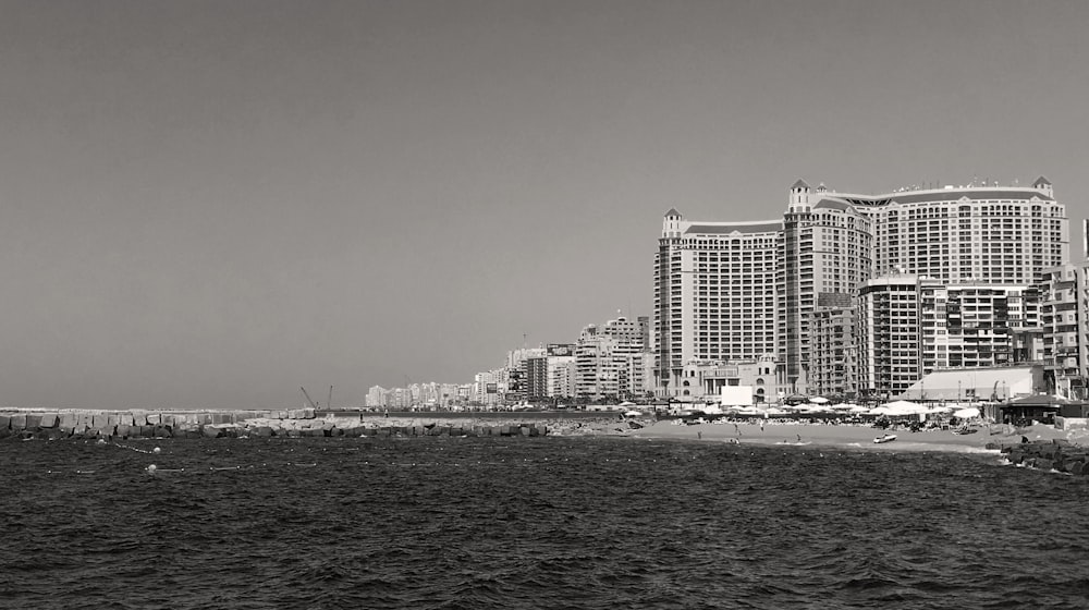 a black and white photo of a beach and buildings