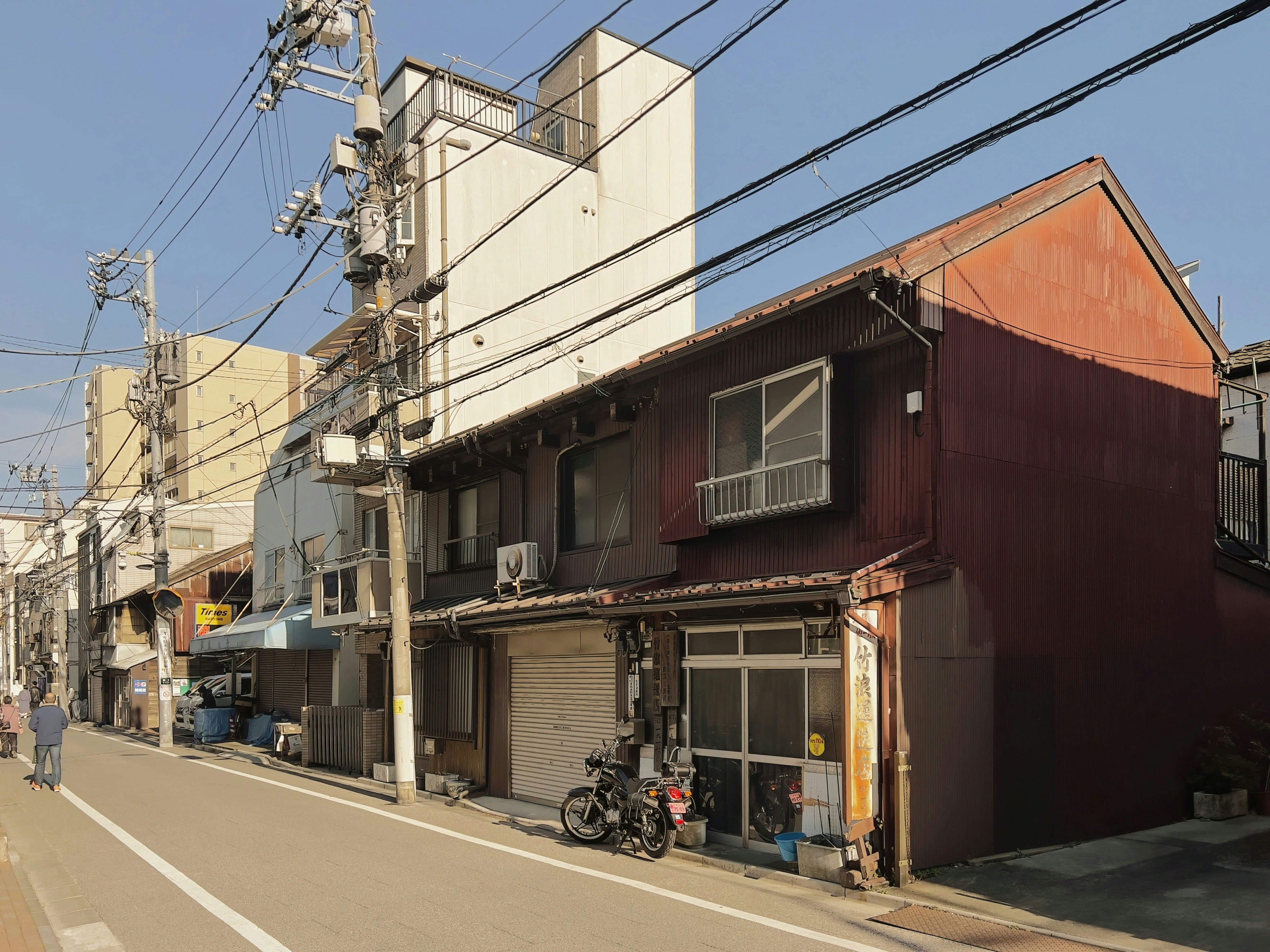 a person walking down a street next to a building