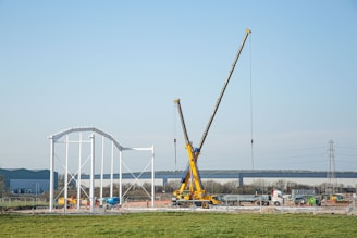 a large crane sitting on top of a lush green field