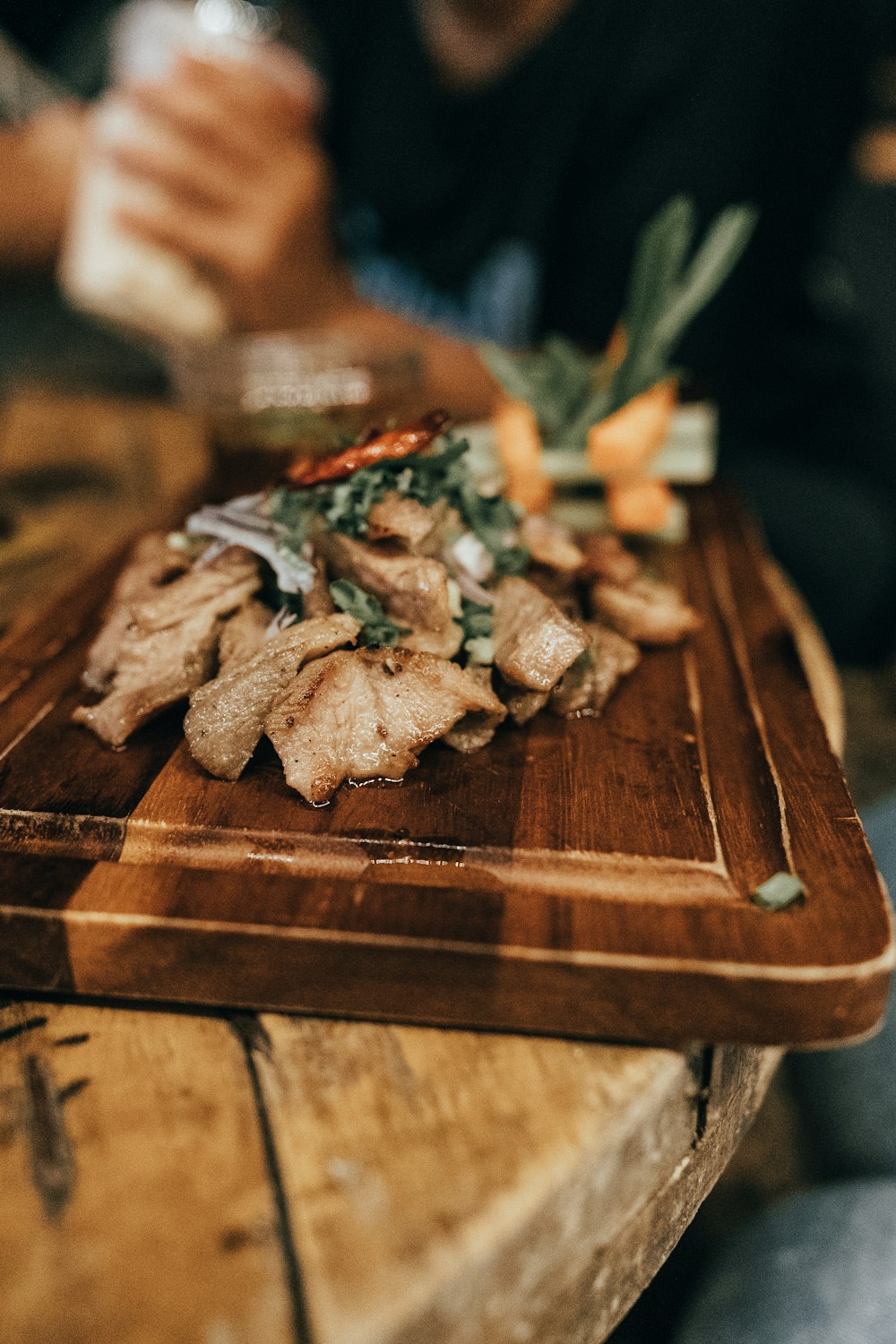 a wooden cutting board topped with food on top of a table