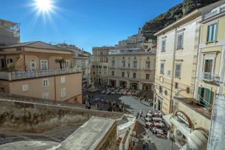 A vibrant town square bathed in sunlight with solar panels on nearby rooftops and happy people enjoying the outdoors.