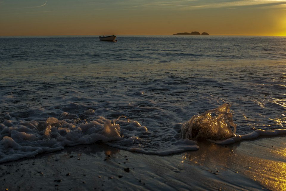 The sun setting over the sea with a ferry boat near Positano