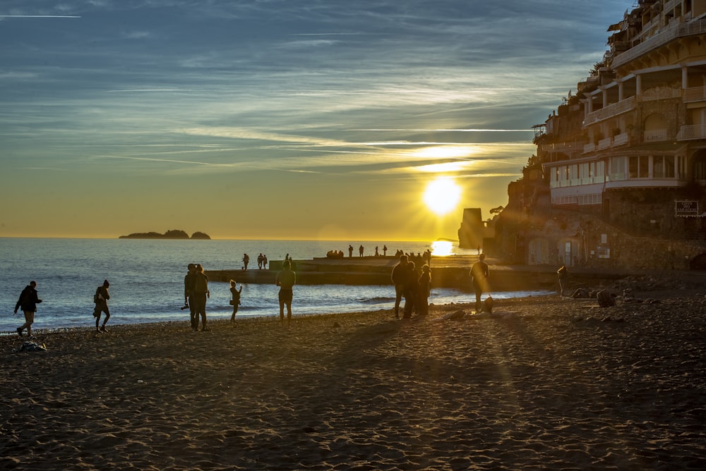 a group of people standing on top of a sandy beach