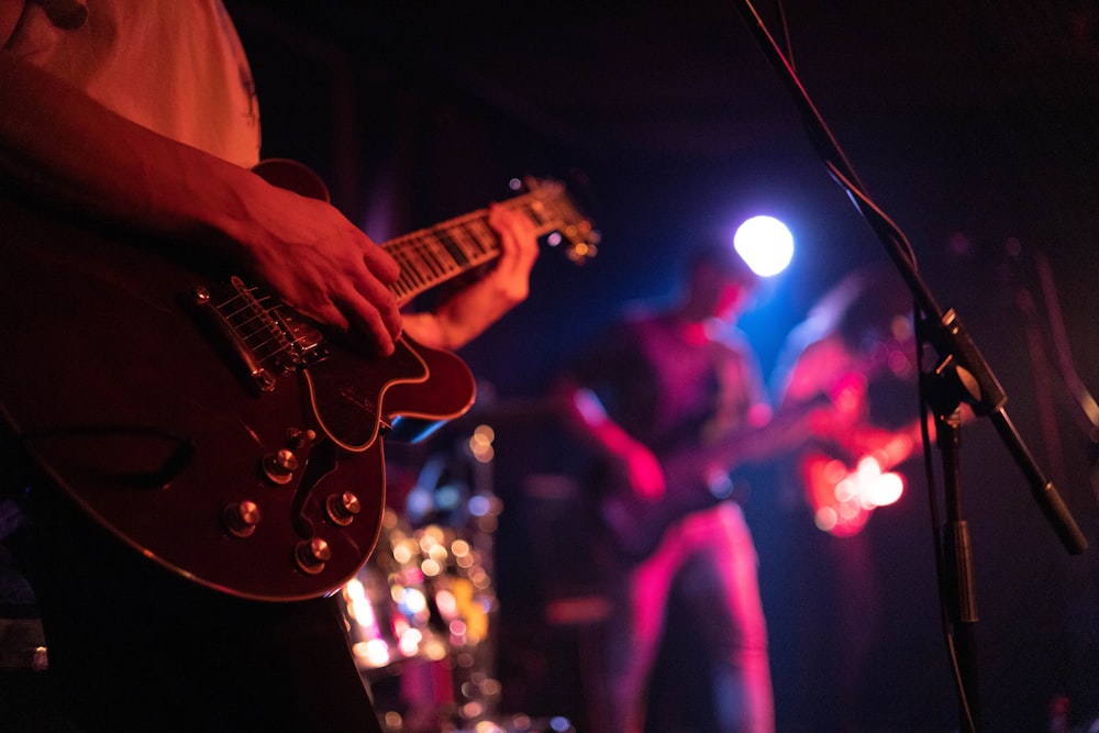 a man playing a guitar in front of a microphone