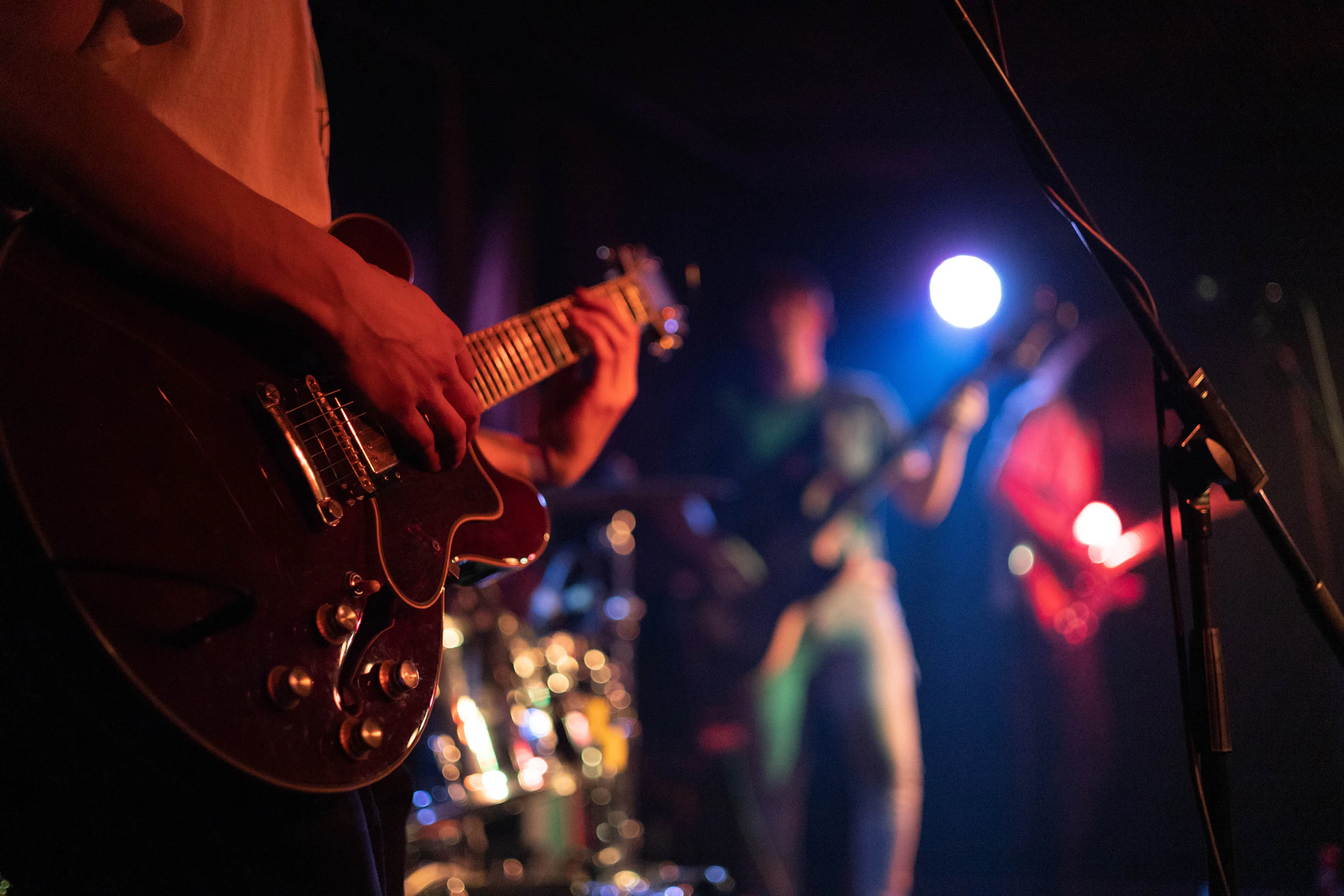 a man playing a guitar in front of a microphone