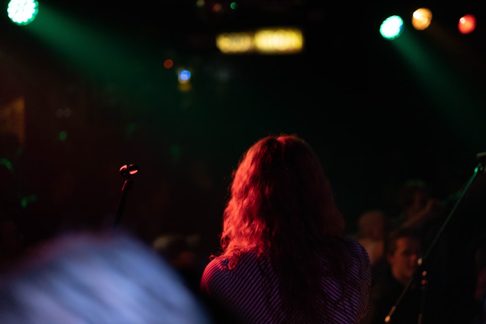a woman standing in front of a microphone at a concert