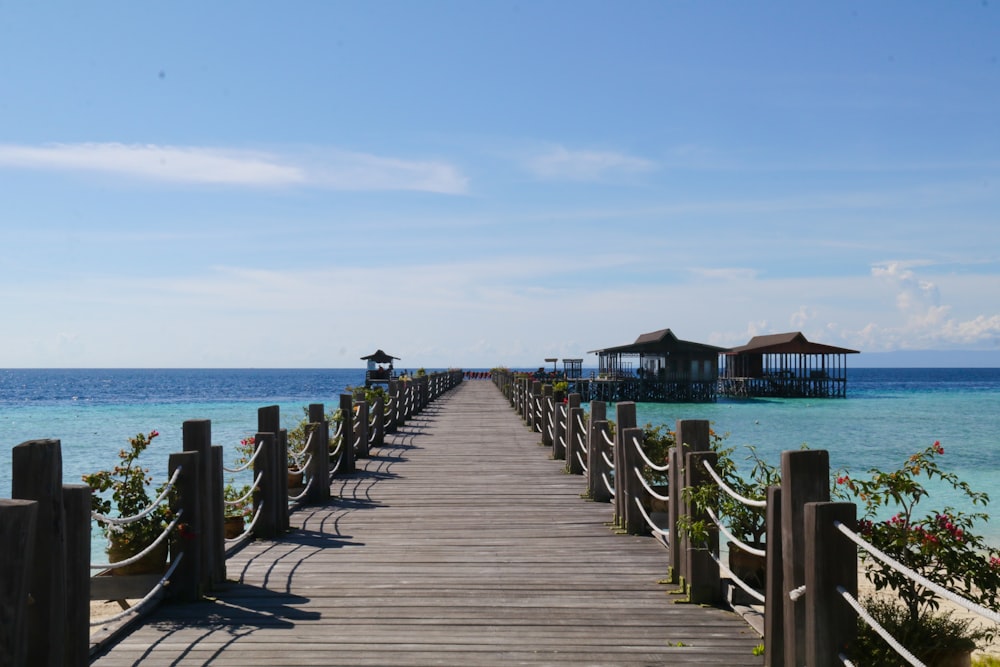 a wooden walkway leading to a beach with a gazebo in the distance