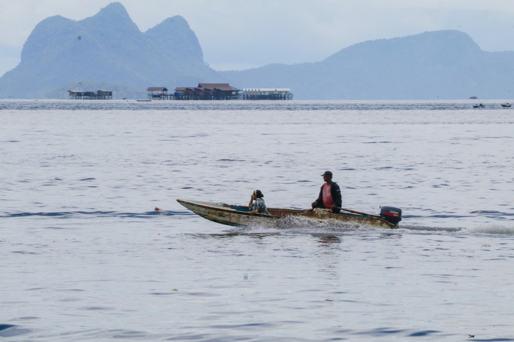 duas pessoas em um barco pequeno em um corpo de água