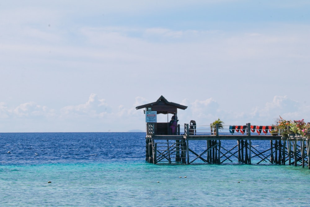 a pier on the ocean with people standing on it