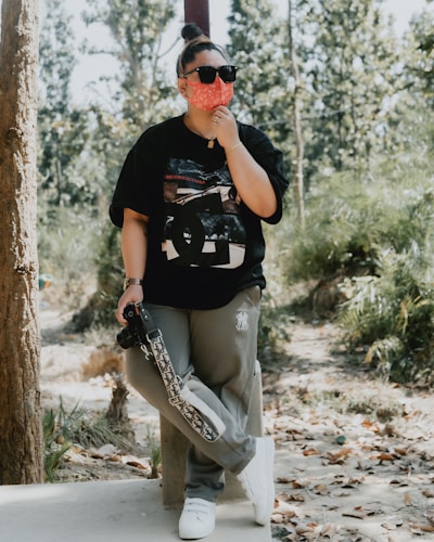 a woman in a black shirt is holding a skateboard