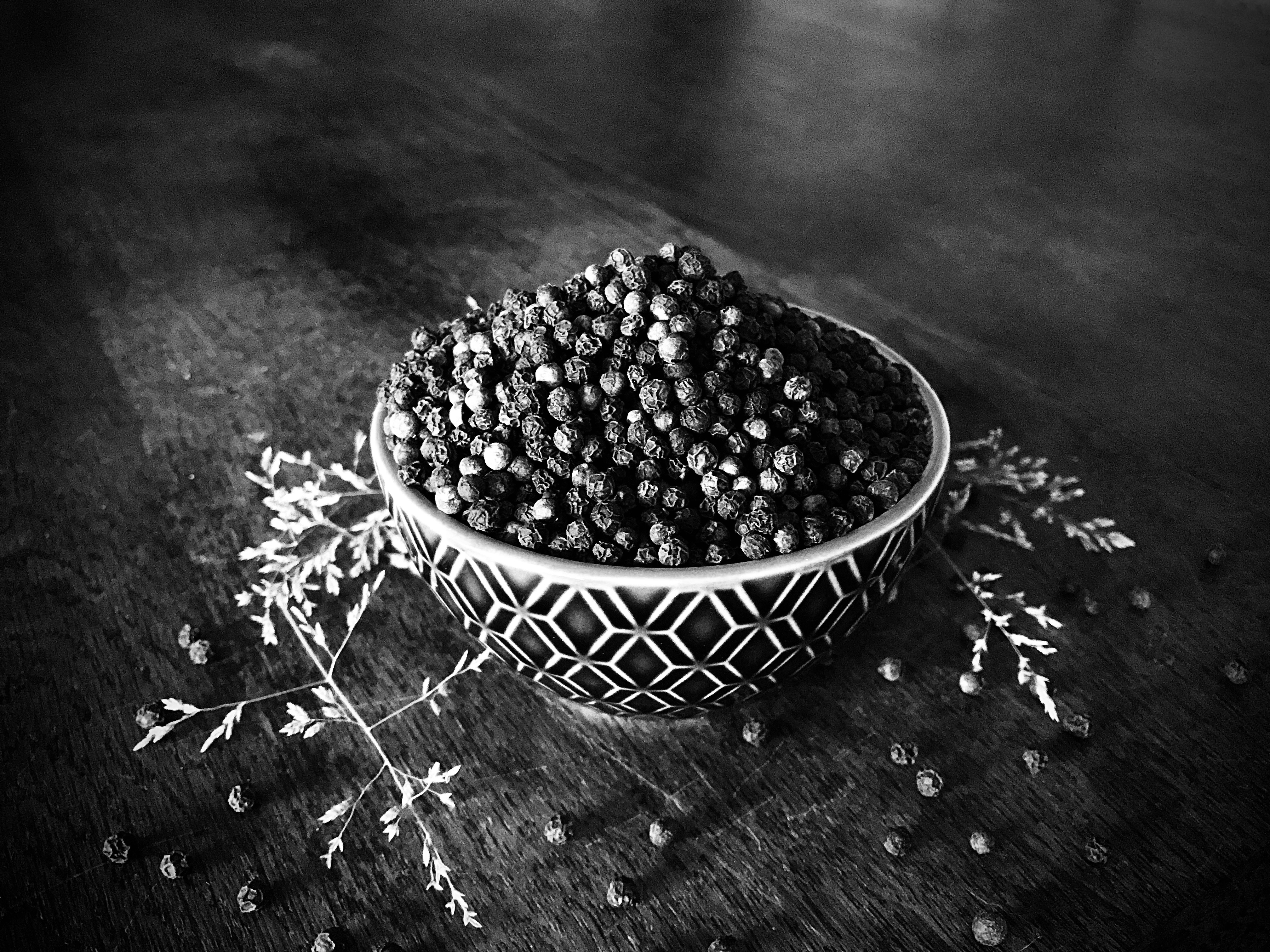 a bowl filled with berries sitting on top of a wooden table