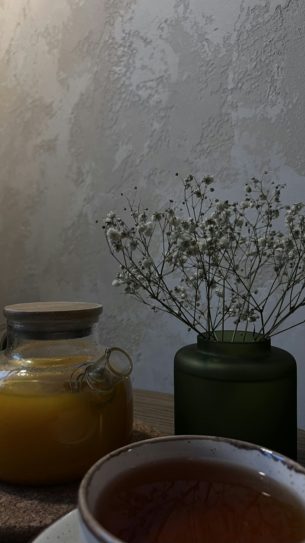 a bowl of soup and a vase of flowers on a table