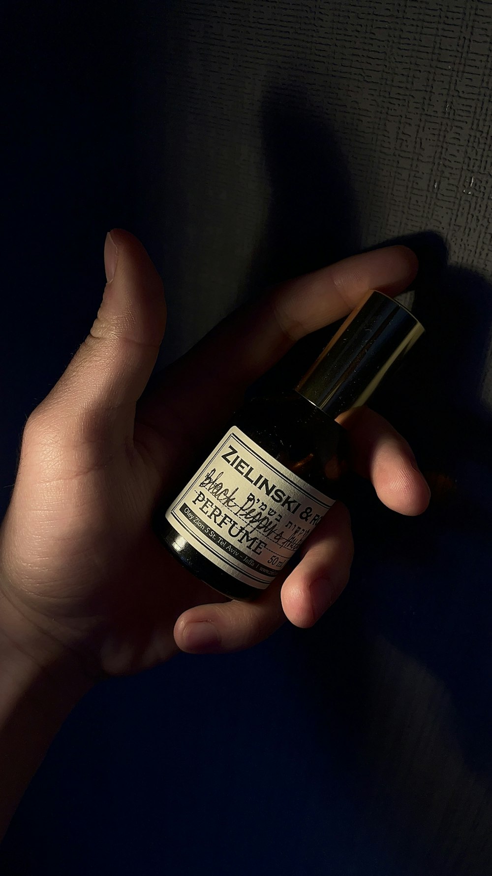 a person holding a small bottle of essential oil