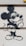 A graffiti-style drawing on a wall depicts a well-known cartoon mouse character wearing sunglasses and giving a cheeky expression with one hand gesturing. The artwork uses bold black outlines on a light-colored surface.
