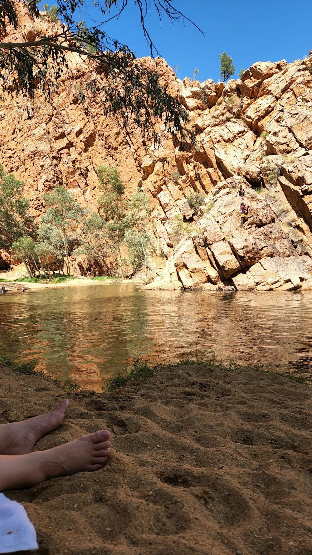 a person laying on a beach next to a body of water