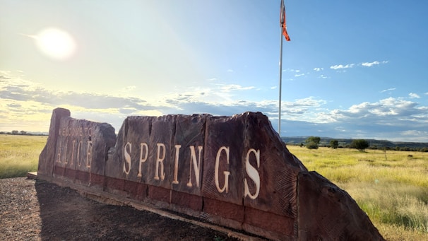 A rustic audio-video guestbook setup glowing warmly against the red desert sunset in Alice Springs.