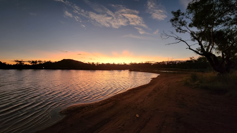 the sun is setting over a body of water