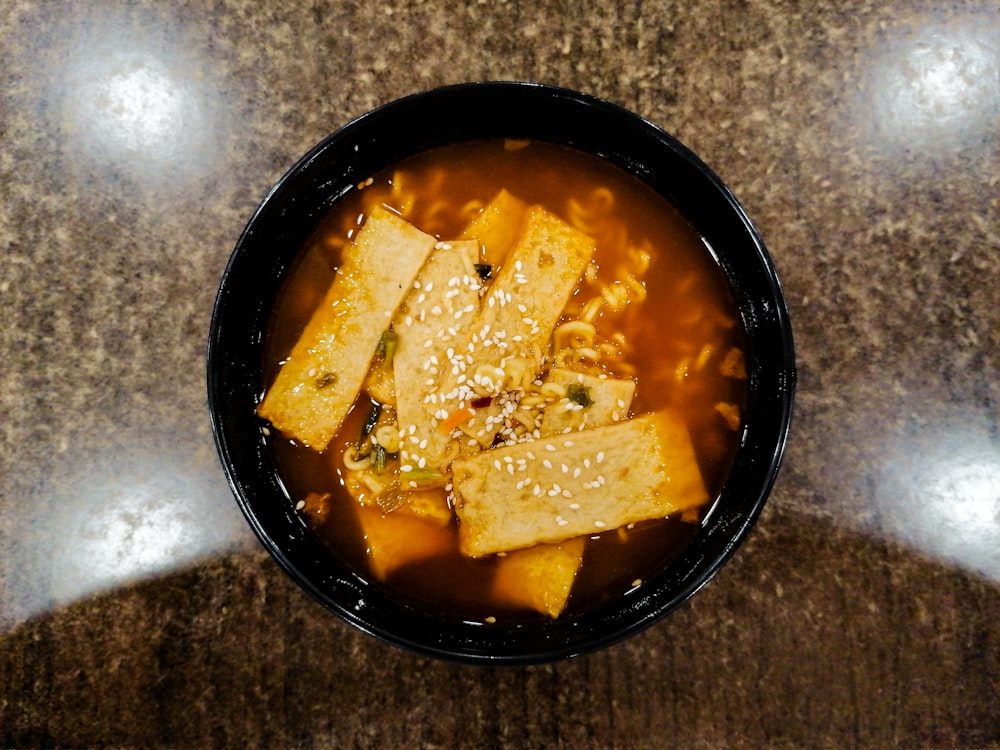 a bowl of soup with tofu and broth