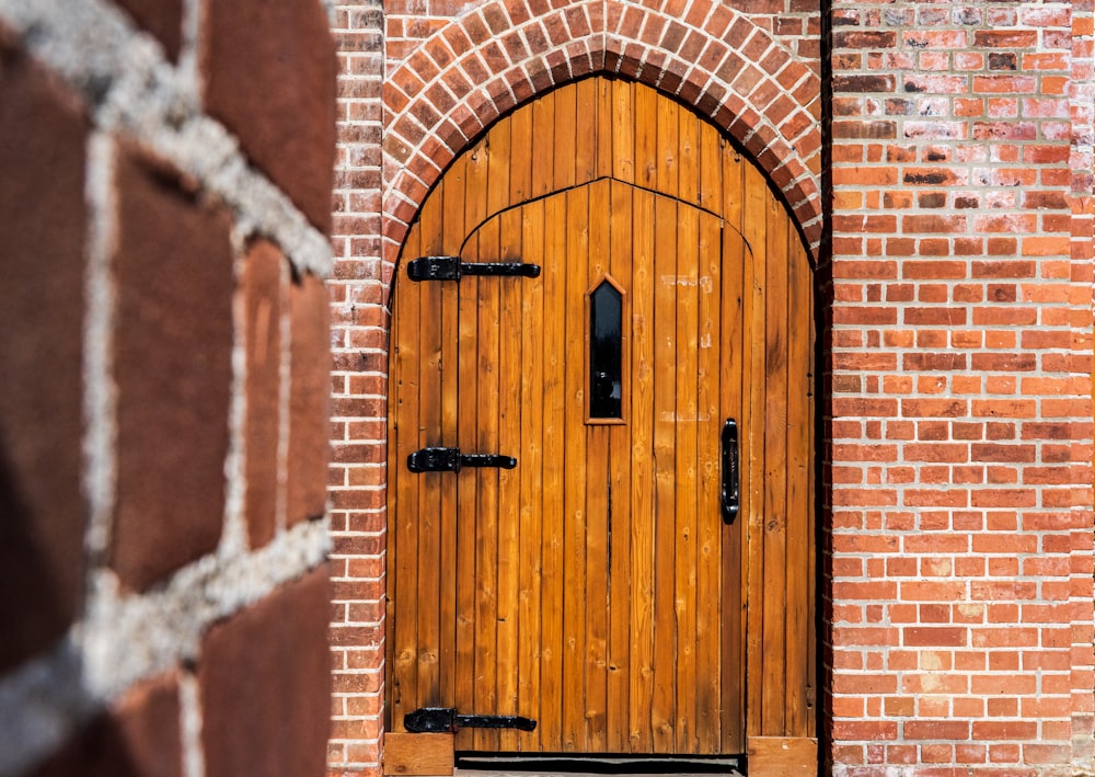 a close up of a wooden door on a brick building