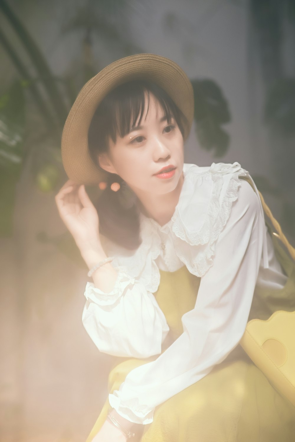 a woman wearing a hat sitting on a yellow chair