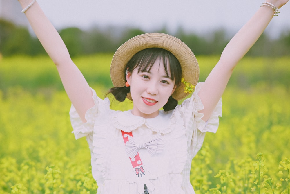 a girl in a field with her arms in the air