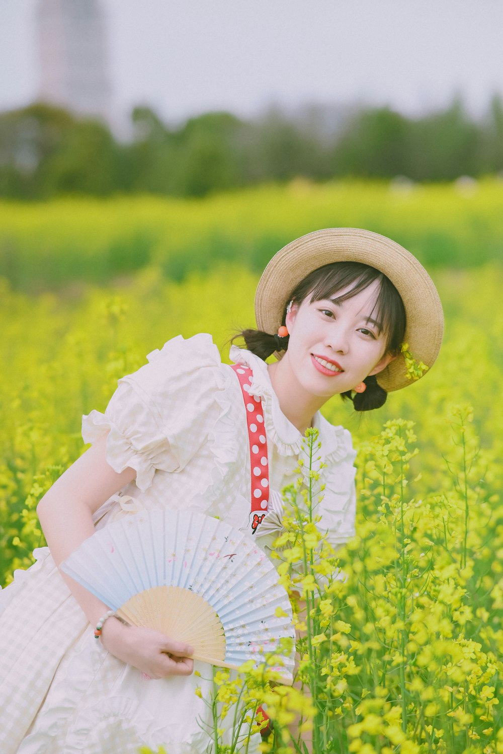 a woman in a field holding a fan