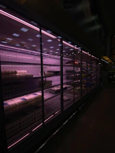 Nighttime grocery store shelves warmly lit with rustic Mediterranean goods and deep burgundy overlays.