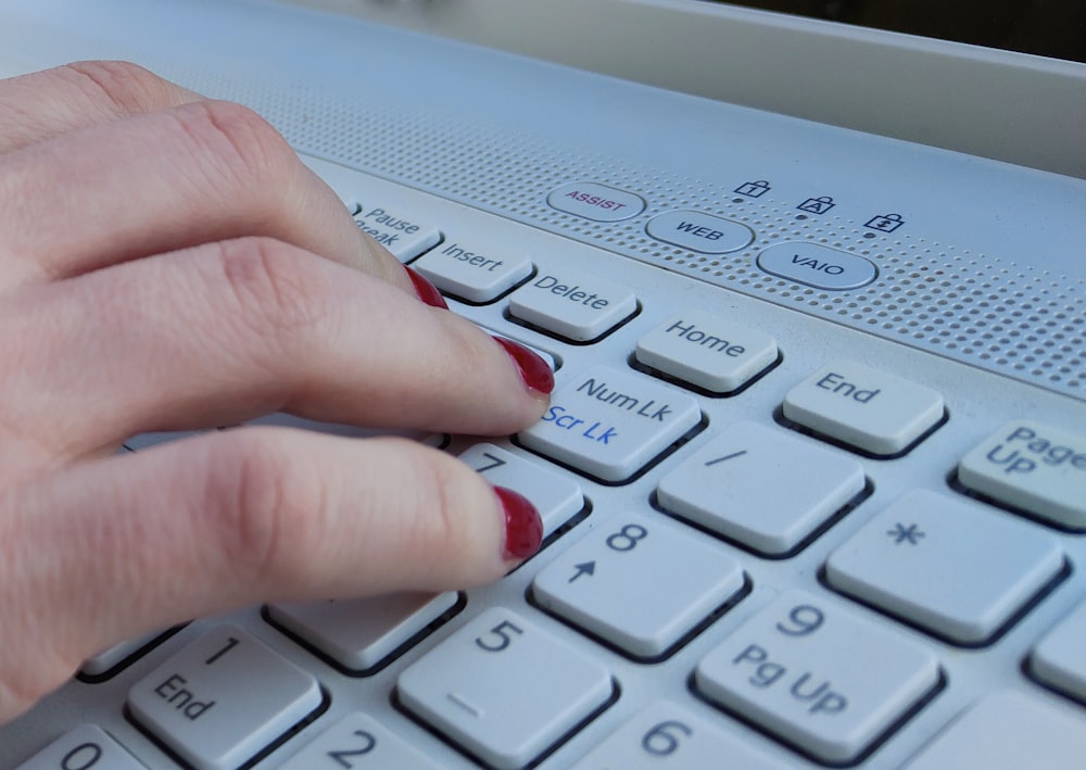 a woman's hand on a computer keyboard