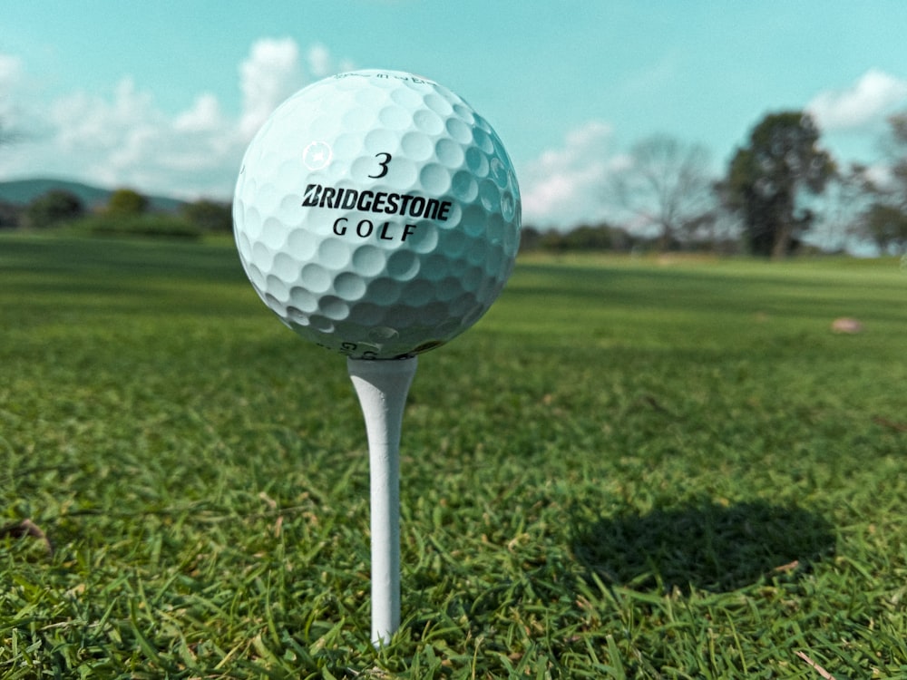 uma bola de golfe sentada em cima de uma camiseta branca