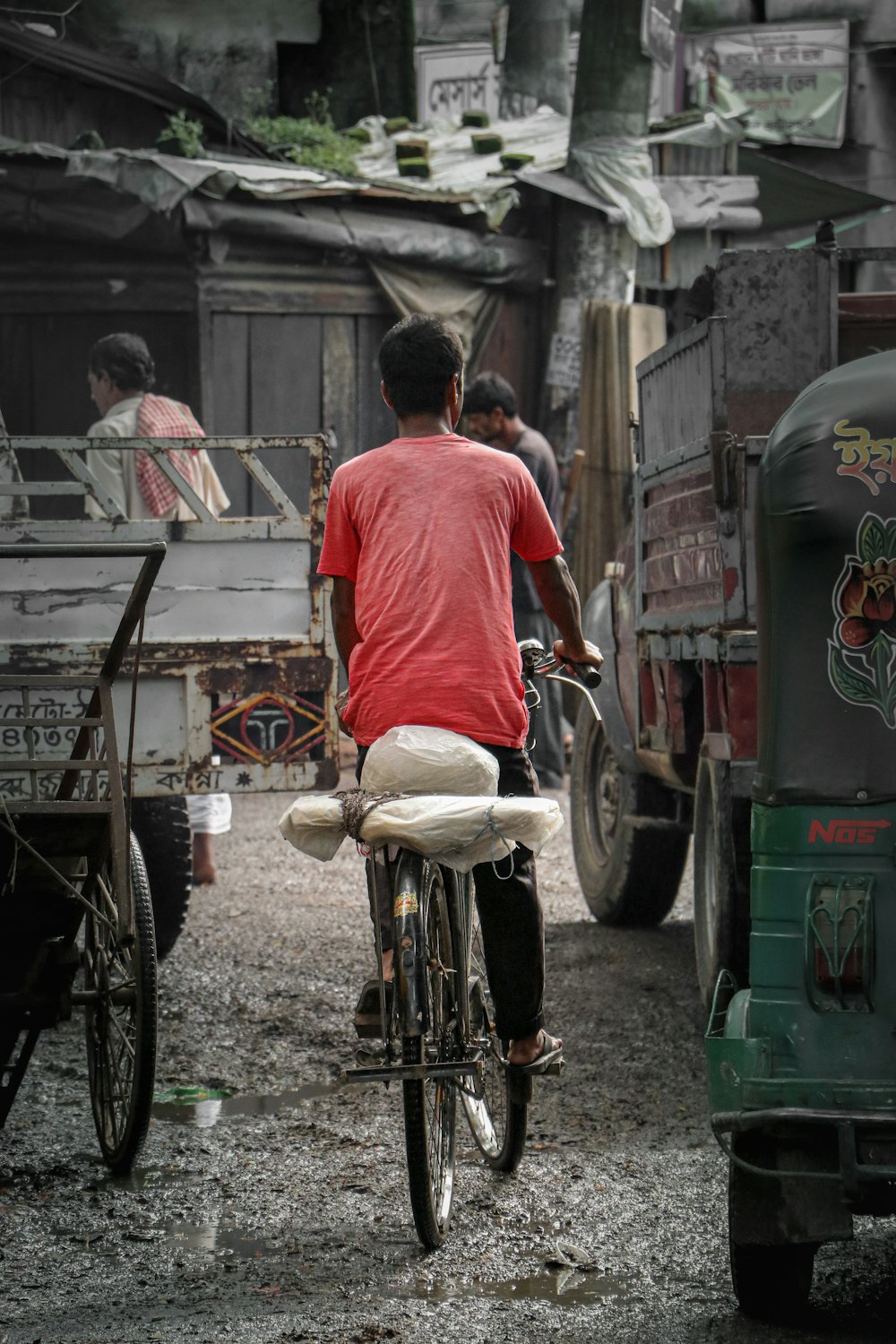 Ein Mann fährt mit dem Fahrrad eine unbefestigte Straße hinunter