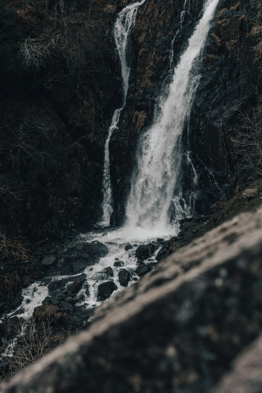 a waterfall is seen from the side of a cliff