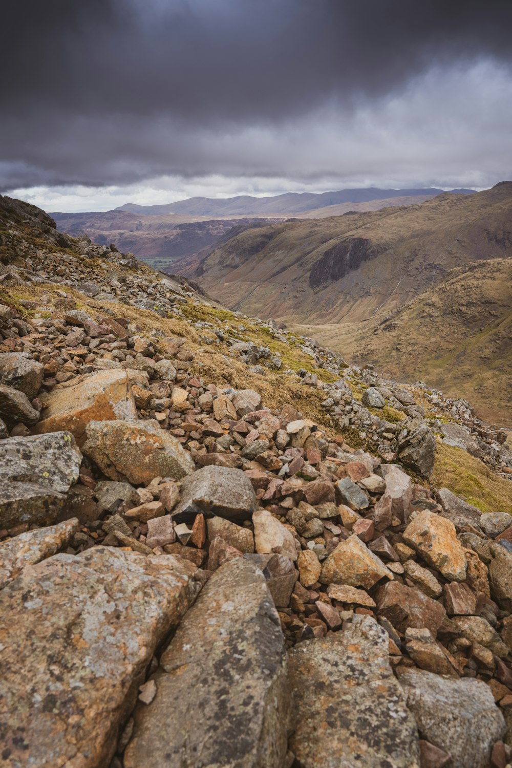 a rocky mountain side with a cloudy sky in the background