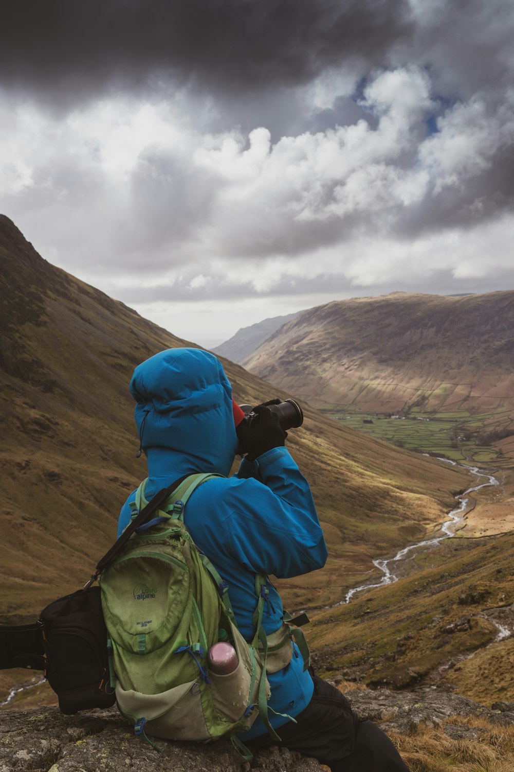 a person sitting on a rock taking a picture