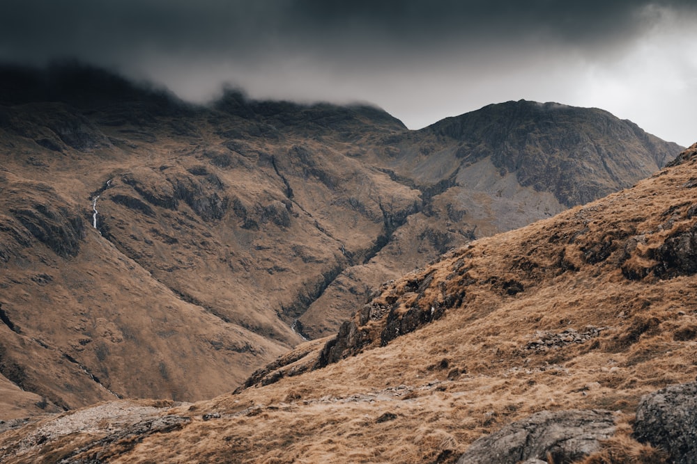 a view of a mountain range from the top of a hill