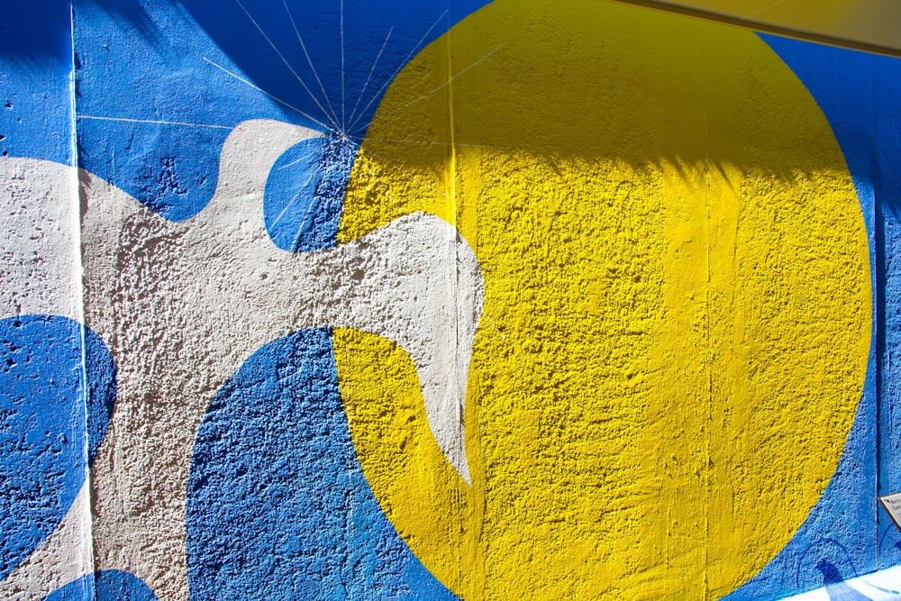 a blue and yellow painted wall with a yellow and white balloon