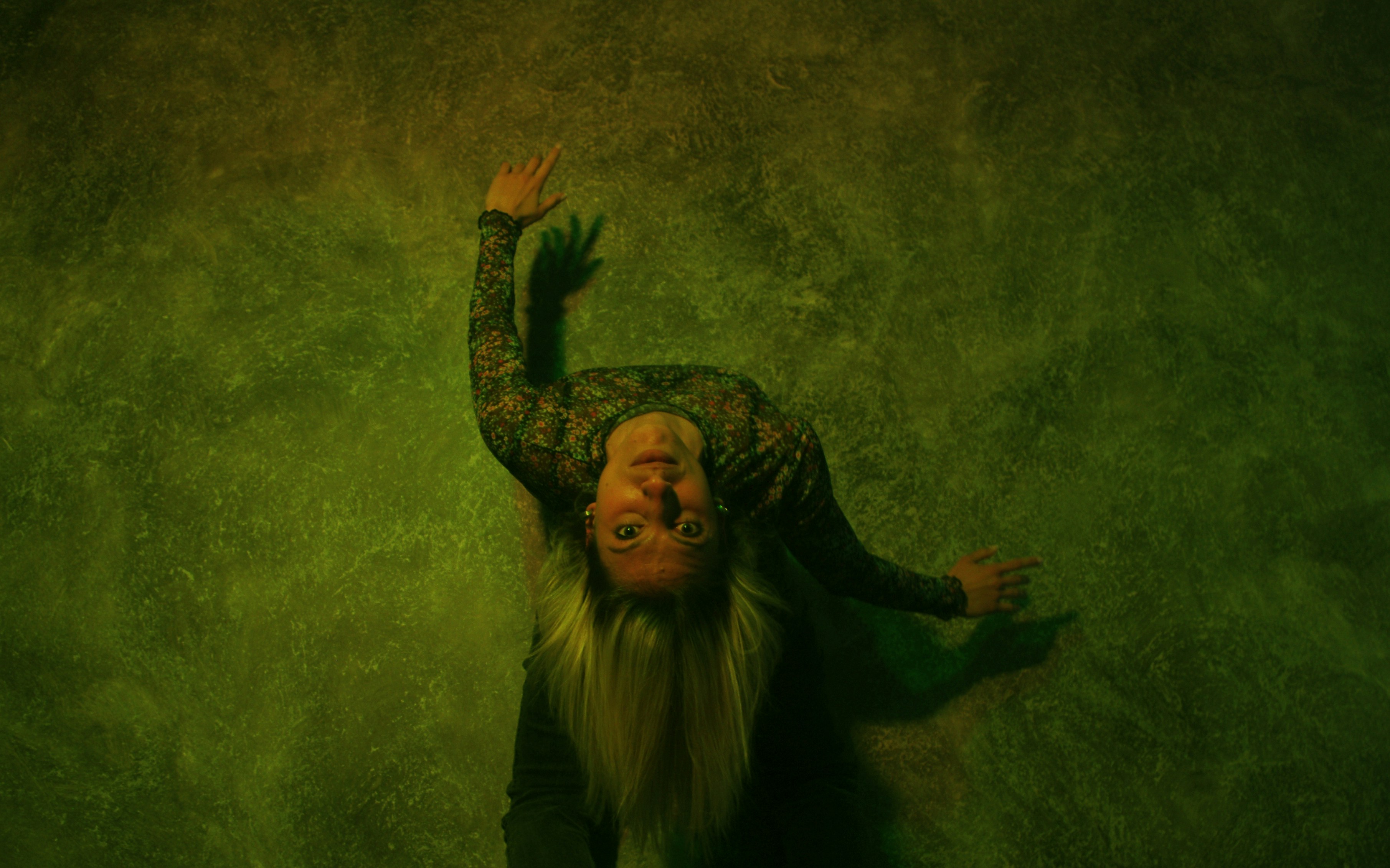 a man with long white hair and a long beard standing in front of a green