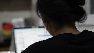 a woman sitting in front of a laptop computer