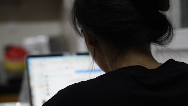 a woman sitting in front of a laptop computer