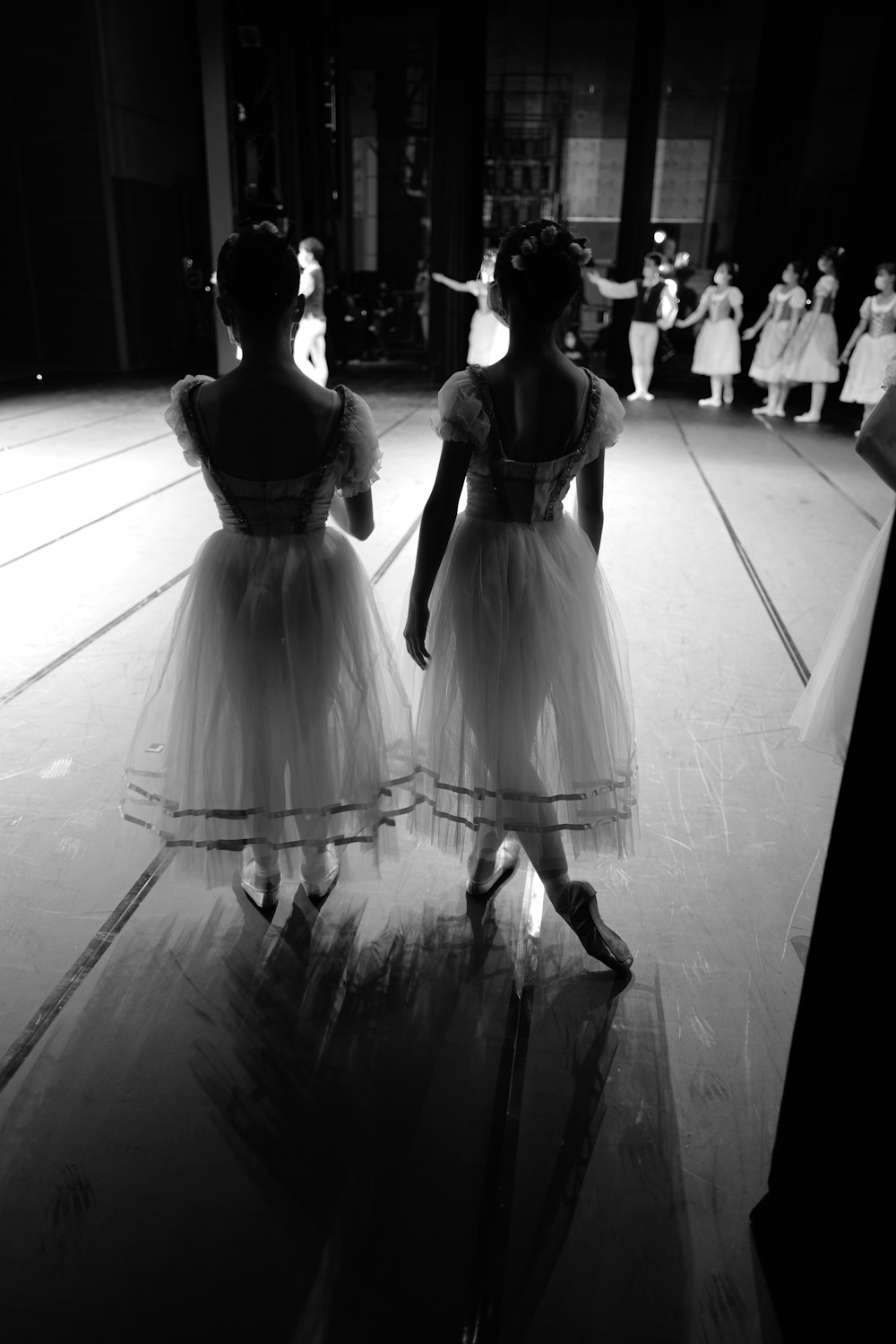 two little girls in dresses are standing on a stage