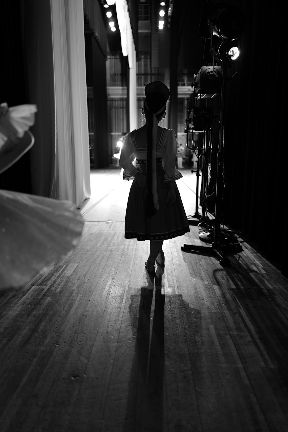 a woman in a dress walking down a hall