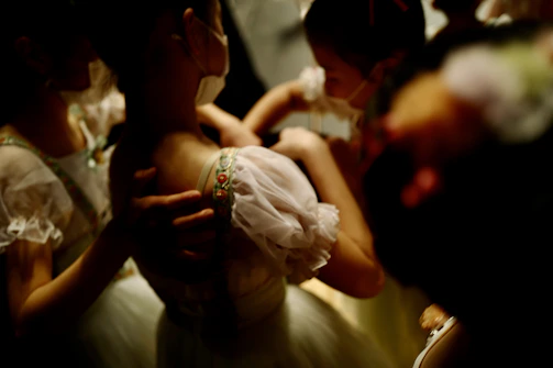 Behind-the-scenes shot of students preparing outfits and adjusting details before the show.