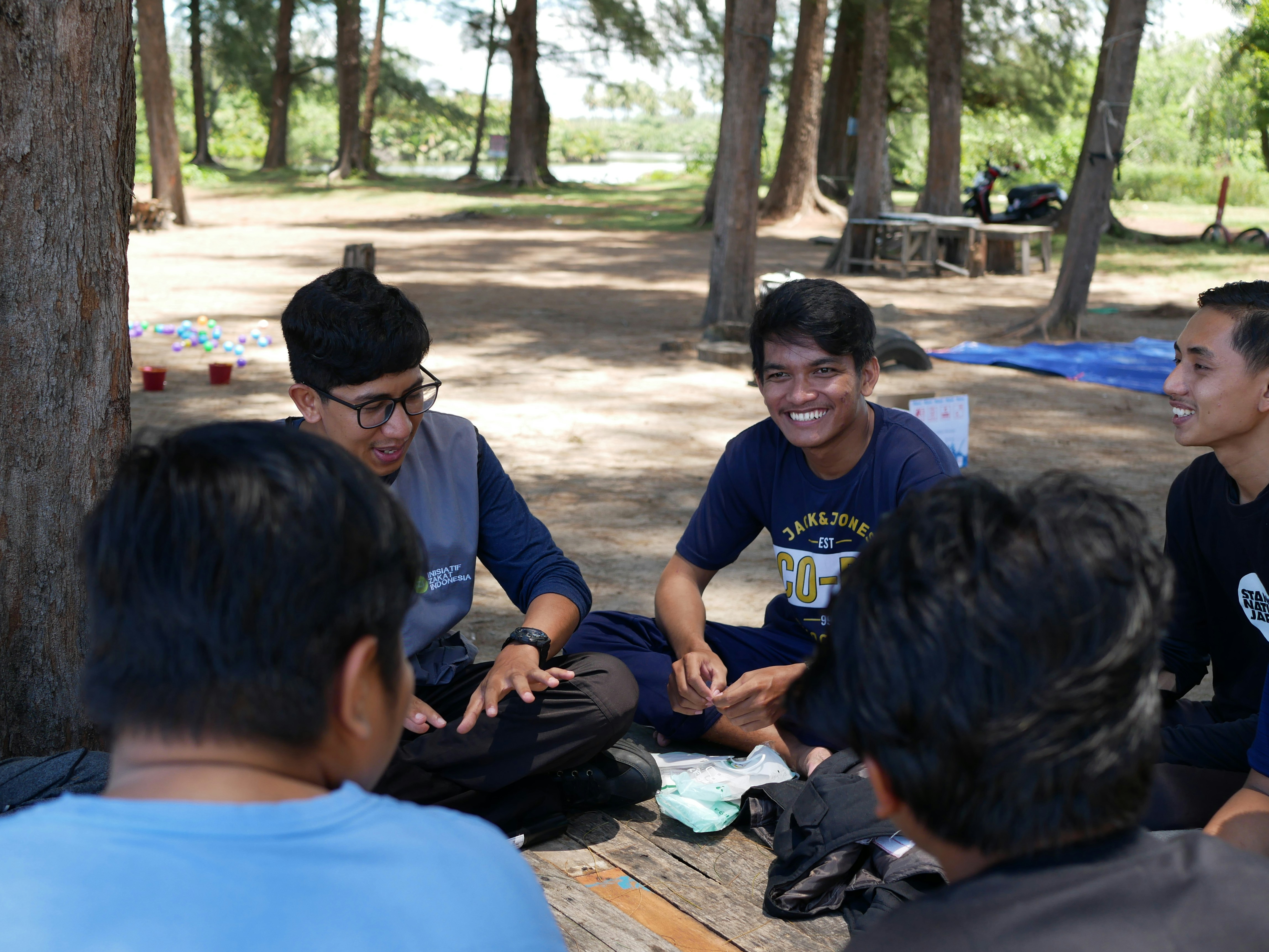 a group of young men sitting on top of a picnic table