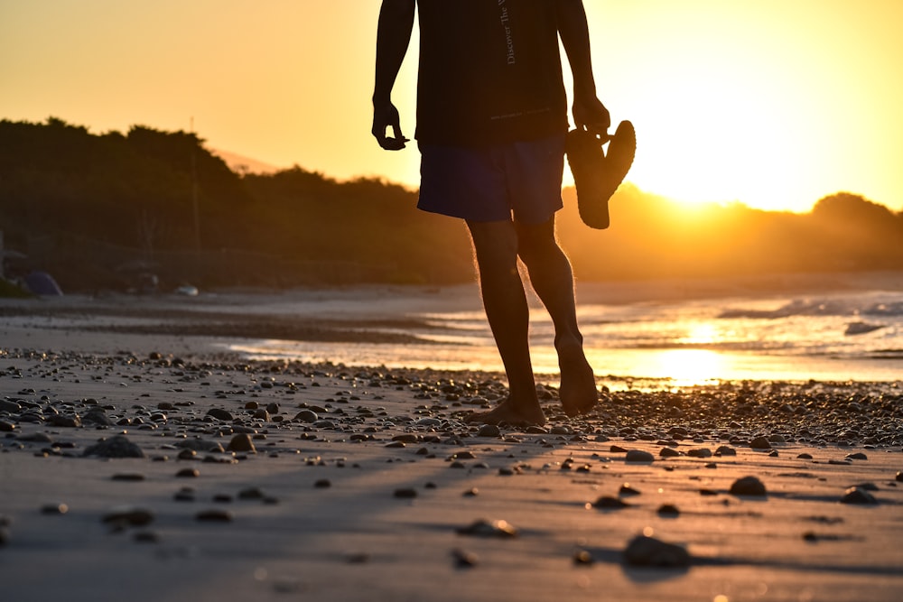 a man standing on top of a sandy beach next to the ocean