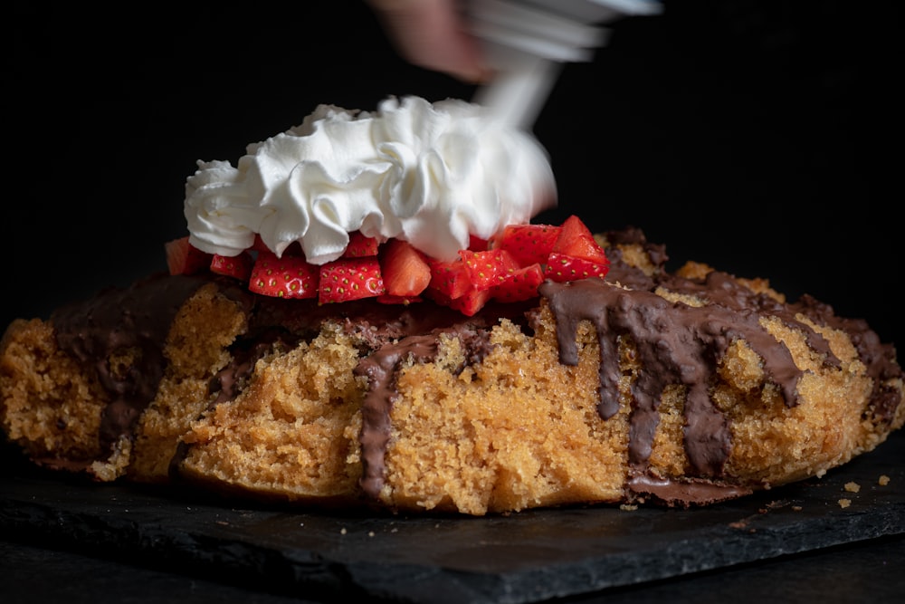 a piece of cake with whipped cream and strawberries on top